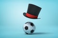 3d rendering of football and black tophat floating in air above ball on light blue background.