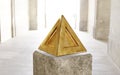 3d rendering of a golden pyramid on the background of a light room Royalty Free Stock Photo