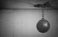 3d rendering of a heavy wrecking ball hangs on its chain from a large uneven ceiling hole. Royalty Free Stock Photo