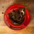 3D Rendering of Hot Coffee Spills out of a Red Cup in a Coffeshop Top View with a Heart shape Droplets at the Top