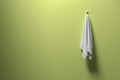 3D rendering : illustration of a piece of clean and white towel hanging on a green pastel wall,light and shadow,copy space Royalty Free Stock Photo