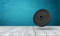 3d rendering of 25 kg weight plate on white wooden floor and dark turquoise background