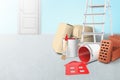3d rendering of ladder, paper bundles, bricks and buckets of red paint, one bucket lying sidelong with red paint spilt