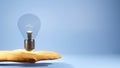 3D Rendering of A light bulb on the hand on isolated blue background. There is a blank space for text. Education concept. Royalty Free Stock Photo