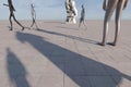 3D rendering of metallic sculptural figures and stone sculpture on a large paved area