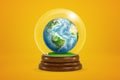 3d rendering of miniature planet Earth inside glass ball globe on amber background.