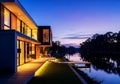 3D rendering of modern house by river at evening, peaceful waterside property, architectural visualization Royalty Free Stock Photo