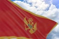 3D rendering of Montenegro flag waving on blue sky background