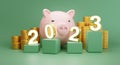 3d rendering. 2023 number on green cubic with pink piggy bank, gold coins stack on green background. investment concept.