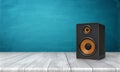 3d rendering of a one black speaker box with orange trim standing on a wooden table in front of a blue background. Royalty Free Stock Photo