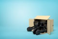 3d rendering of open cardboard box lying sidelong with black headphones inside on light-blue background with copy space.