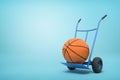 3d rendering of orange basketball ball on a hand truck on blue background Royalty Free Stock Photo