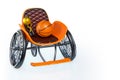 3d rendering of orange modern sports wheelchair with golden trophy and basketball on top, isolated on white background