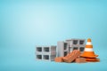 3d rendering of pile of gray hollow and red perforated bricks with orange and white safety cone standing beside on light