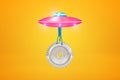 3d rendering of pink metal UFO carrying big silver gear wheel on yellow background Royalty Free Stock Photo