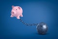 3d rendering of pink piggy bank chained to metal ball on blue background. Royalty Free Stock Photo