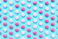 3D rendering of pink and white coated chocolate candy gems on a blue background Royalty Free Stock Photo