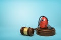 3d rendering of red vacuum cleaner on round wooden block and brown wooden gavel on blue background Royalty Free Stock Photo