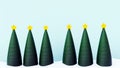 a row of Christmas trees with yellow stars on top, standing in a snowy ground Royalty Free Stock Photo