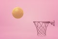 3d rendering of shiny gold orange basketball flying into pink hoop on yogurt pink background.