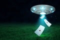 3d rendering of silver metal UFO with playing ace heart cards on dark night sky and green grass background Royalty Free Stock Photo