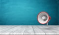 3d rendering of a single red and white megaphone hanging vertically above a wooden desk.