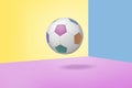 3d rendering of a single soccer ball with colorful patches hands on three-colored pastel background.