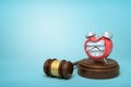 3d rendering of smashed broken alarn clock on round wooden block and brown wooden gavel on blue background