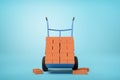 3d rendering of stack of red perforated bricks on blue hand truck with several bricks on ground on light-blue background Royalty Free Stock Photo