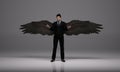 3D rendering : a standing man with a pair of wings at his back pose in black business suit Royalty Free Stock Photo