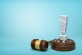 3d rendering of stone exclamation mark standing on sounding block with gavel beside on light-blue background with copy