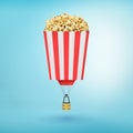 3d rendering of a striped pop corn box with a little hot air-balloon gondola attached to it.