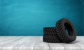 3d rendering of three black tractor wheels on white wooden floor and dark turquoise background Royalty Free Stock Photo