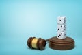 3d rendering of three white dice standing on top of each other on sounding block with gavel lying beside on light-blue Royalty Free Stock Photo