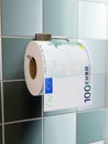 Toilet paper roll with imprinted 100 Euro on wall dispenser Royalty Free Stock Photo