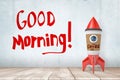 3d rendering of toy rocket made of coffee paper cup, standing on wooden floor, near wall with title `Good Morning`