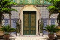 Arabic home facade with front door, yard and palm trees