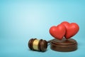 3d rendering of two cute red hearts on sounding block with judge gavel beside on light-blue background with copy space.