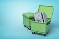 3d rendering of two green trash cans, front can open with bent and broken metal safe inside, on light-blue background.