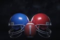 3d rendering of two helmets of different colors standing on both sides of an American football ball. Royalty Free Stock Photo