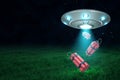 3d rendering of UFO under night sky dropping three dynamite bundles from its open hatch down onto green field.