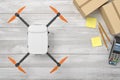 3d rendering of white drone with cardboard boxes, sticky notes, pencils and pin pad on white wooden desk background Royalty Free Stock Photo