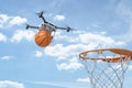 3d rendering of white drone carrying orange basketball ball with hoop on blue sky background Royalty Free Stock Photo