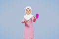 3d rendering of woman muslim greeting, greeting, pointing and holding phone while smiling