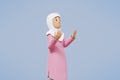 3d rendering of woman muslim greeting, greeting, pointing and holding phone while smiling