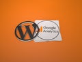 3d rendering of the WordPress and Google Analytics logos against a orange background