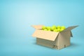 3d rendering of yellow tennis balls in carton box on blue background.