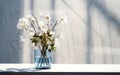 3D Transparent blue glass vase with white rose flower bouquet of green tree twig in outdoor sunlight on concrete counter and wall Royalty Free Stock Photo