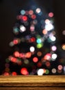 3D wooden table looking out to a defocussed Christmas tree Royalty Free Stock Photo