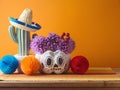 Da de los Muertos day of the dead holiday concept. Sugar skull Halloween pumpkin and Mexican party decorations on wooden table